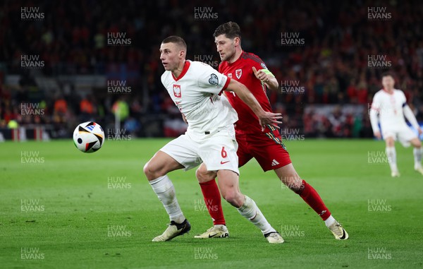 260324 - Wales v Poland, Euro 2024 qualifying Play-off Final - Jakub Piotrowski of Poland holds off Ben Davies of Wales
