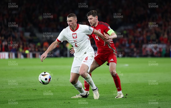 260324 - Wales v Poland, Euro 2024 qualifying Play-off Final - Jakub Piotrowski of Poland holds off Ben Davies of Wales