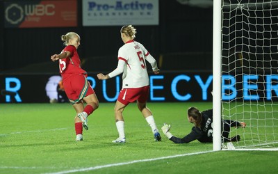 281025 - Wales v Poland, Women’s International Challenge Match -  Elise Hughes of Wales scores the opening goal as she beats Kinga Seweryn of Poland