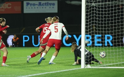 281025 - Wales v Poland, Women’s International Challenge Match -  Elise Hughes of Wales scores the opening goal as she beats Kinga Seweryn of Poland