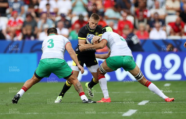 160923 - Wales v Portugal - Rugby World Cup France 2023 - Pool C - Gareth Anscombe of Wales is tackled by Anthony Alves and Steevy Cerqueira of Portugal 