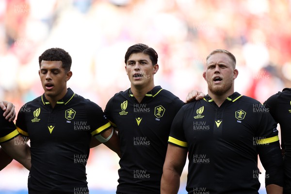 160923 - Wales v Portugal - Rugby World Cup France 2023 - Pool C - Rio Dyer, Louis Rees-Zammit and Corey Domachowski of Wales sing the anthem