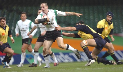 12-11-04. Wales v Romania.  Wales' Gareth Thomas is held back as he tries to brush off tackler  