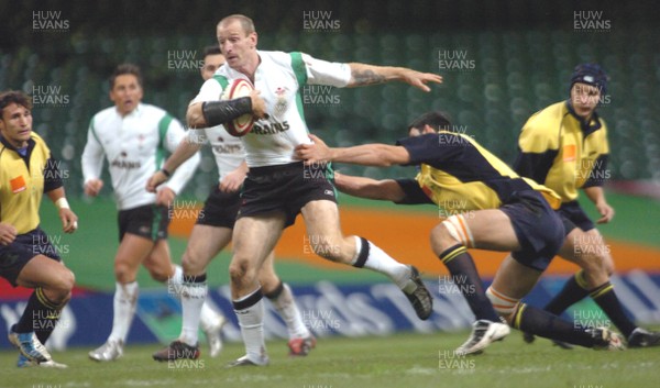 12-11-04. Wales v Romania.  Wales' Gareth Thomas is held back as he tries to brush off tackler  