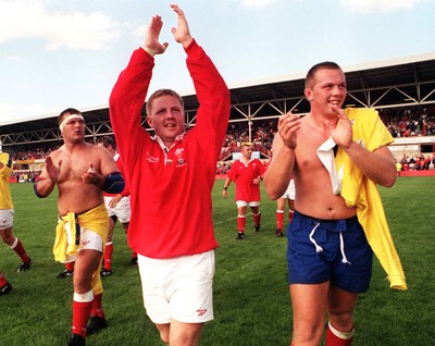 300897 - Wales v Romania - Gwyn Jones (centre) celebrates with Nathan Thomas (right) and Lyndon Mustoe (left)