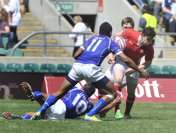 120513 - Wales v Samoa - Bowl Semi Final - HSBC Sevens World Series - Owen Jenkins of Wales is tackled by Reupena Levasa, (10), and Tulolo Tulolo of Samoa (11)