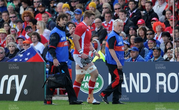 18.09.11 - Wales v Samoa - Rugby World Cup 2011 - Dan Lydiate of Wales leaves the field with physio Mark Davies(L) and team doctor Prof John Williams. 