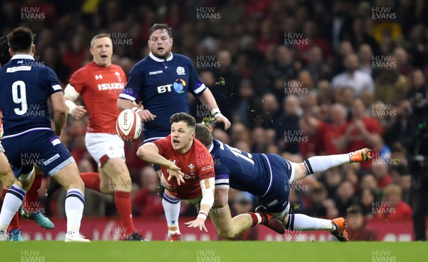 030218 - Wales v Scotland - NatWest 6 Nations 2018 - Steff Evans of Wales gets the ball away as Stuart Hogg of Scotland tackles