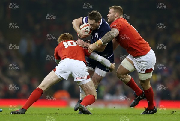 030218 - Wales v Scotland - Natwest 6 Nations - Stuart Hogg of Scotland is tackled by Rhys Patchell and Ross Moriarty of Wales