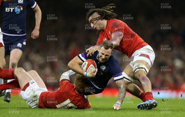 030218 - Wales v Scotland - Natwest 6 Nations - Byron McGuigan of Scotland is tackled by Rhys Patchell and Josh Navidi of Wales