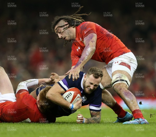 030218 - Wales v Scotland - Natwest 6 Nations - Byron McGuigan of Scotland is tackled by Rhys Patchell and Josh Navidi of Wales