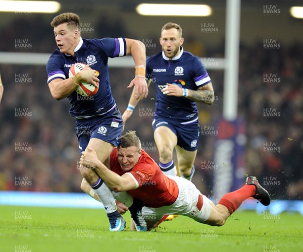 030218 - Wales v Scotland - NatWest 6 Nations - Huw Jones of Scotland is tackled by Hadleigh Parkes of Wales 