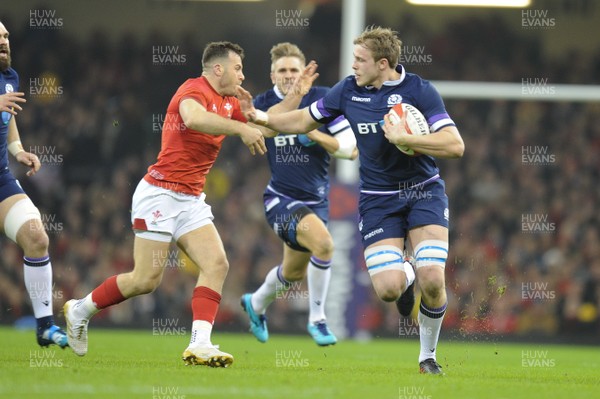030218 - Wales v Scotland - NatWest 6 Nations - Jonny Gray of Scotland is tackled by Gareth Davies of Wales 