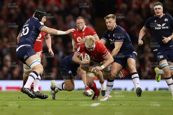 030224 - Wales v Scotland - Guinness 6 Nations 2024 - Aaron Wainwright of Wales is tackled by Scott Cummings of Scotland 