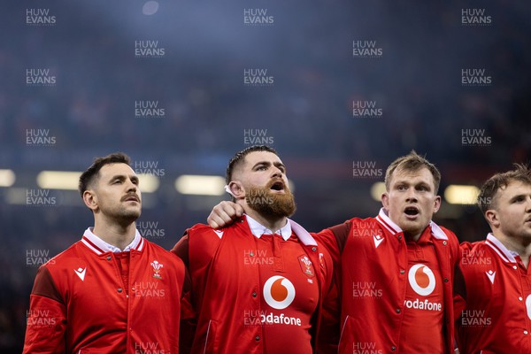 030224 - Wales v Scotland - Guinness 6 Nations 2024 - Tomos Williams, Kemsley Mathias and Nick Tompkins of Wales during the anthem