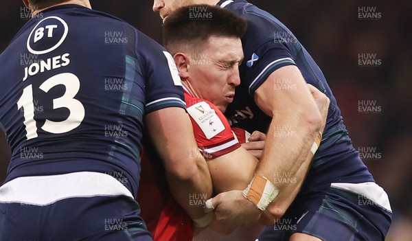 030224 - Wales v Scotland, Guinness Six Nations 2024 - Josh Adams of Wales is tackled by Huw Jones of Scotland and Kyle Steyn of Scotland