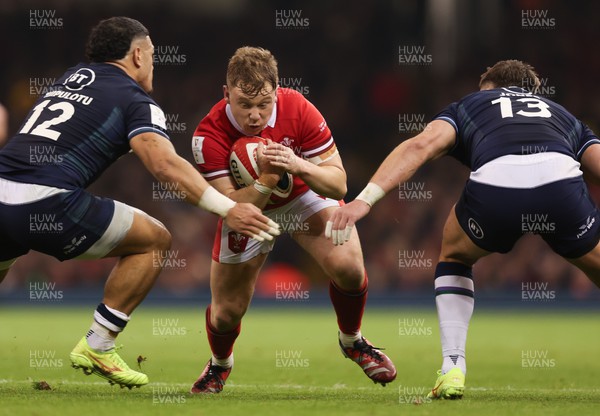 030224 - Wales v Scotland, Guinness Six Nations 2024 - Sam Costelow of Wales takes on Sione Tuipulotu of Scotland and Huw Jones of Scotland