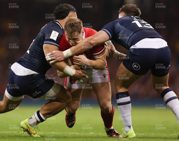 030224 - Wales v Scotland, Guinness Six Nations 2024 - Sam Costelow of Wales takes on Sione Tuipulotu of Scotland and Huw Jones of Scotland