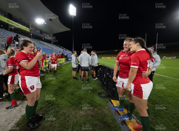 091022 - Wales v Scotland, Women’s Rugby World Cup 2021 Pool A - Cerys Hale of Wales photographs Carys Phillips of Wales and Ffion Lewis of Wales at the end of the match