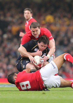 120212 - Wales v Scotland - RBS 6 Nations -Scotland's Allan Jacobsen is tackled by Wales' Mike Phillips and Ian Evans