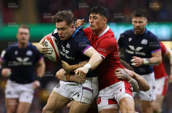 120222 - Wales v Scotland - Guinness Six Nations Championship - Darcy Graham of Scotland is tackled by Louis Rees-Zammit of Wales