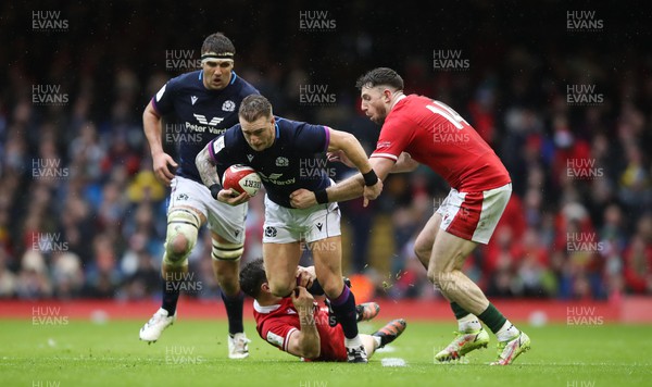 120222 - Wales v Scotland 2022 Guinness Six Nations - Stuart Hogg of Scotland takes on Tomos Williams of Wales and Alex Cuthbert of Wales