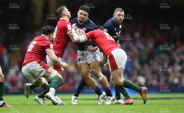 120222 - Wales v Scotland 2022 Guinness Six Nations - Sione Tuipulotu of Scotland is tackled by Dan Biggar of Wales  and Nick Tompkins of Wales