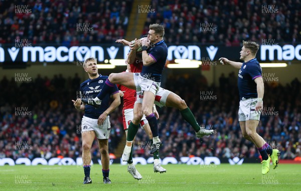 120222 - Wales v Scotland 2022 Guinness Six Nations - Stuart Hogg of Scotland takes the ball as Louis Rees-Zammit of Wales  challenges