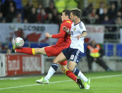 121012 - Wales v Scotland - FIFA 2014 World Cup Qualifying Campaign - Gareth Bale of Wales, left, competes for the ball with Daniel Fox of Scotland