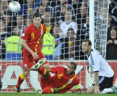 121012 - Wales v Scotland - FIFA 2014 World Cup Qualifying Campaign - Ashley WIlliams of Wales, middle, clears the ball from Steven Fletcher of Scotland 