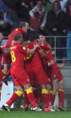 121012 - Wales v Scotland,  FIFA 2014 World Cup Qualifier -Wales' Gareth Bale is mobbed by teammate after he scores the second goal