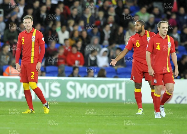 121012 - Wales v Scotland - FIFA 2014 World Cup Qualifying Campaign - Ashley Williams of Wales, middle, is seen, reacting to team mate Chris Gunter, left, after Scotland score the first goal