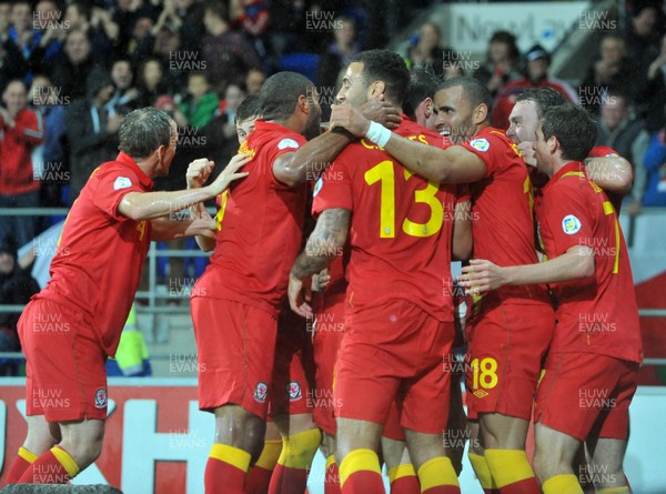 121012 - Wales v Scotland - FIFA 2014 World Cup Qualifying Campaign - Wales team members mob Gareth Bale of Wales after he scores the winner 