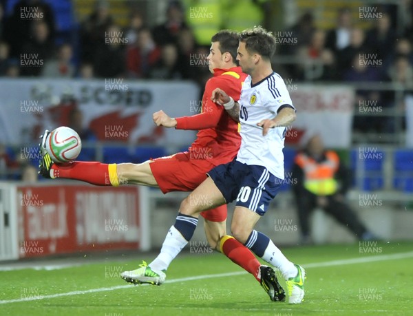121012 - Wales v Scotland - FIFA 2014 World Cup Qualifying Campaign - Gareth Bale of Wales, left, competes for the ball with Daniel Fox of Scotland