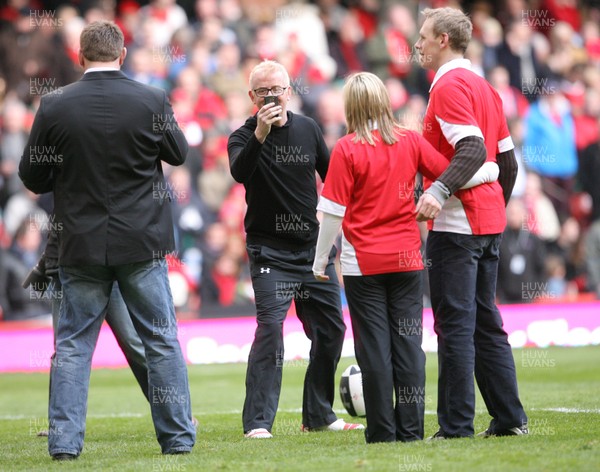 13.02.10 Wales v Scotland... Radio 2 DJ Chris Evans uses his phone to take pictures while on the pitch of the Millennium Stadium during half time. .
