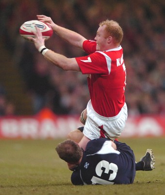 12.02.06  Wales v Scotland  Martyn Williams passes as Ben MacDougall tackles  