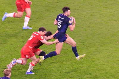 210226 - Wales v Scotland - Guinness Six Nations - Tomos Williams and Alex Mann of Wales tackle Blair Kinghorn of Scotland
