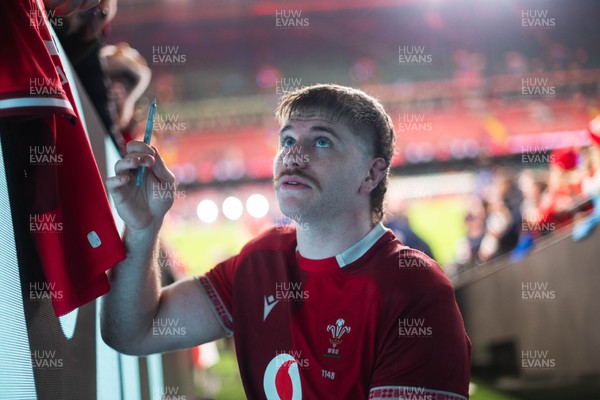 210226 - Wales v Scotland - Guinness Six Nations - Aaron Wainwright signs autographs for fans in the tunnel after the game 