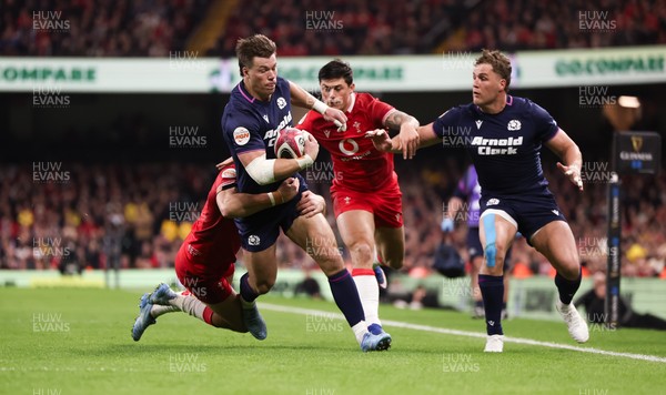 210226 - Wales v Scotland, 2026 Guinness Six Nations - Huw Jones of Scotland takes on Josh Adams of Wales and Louis Rees-Zammit of Wales