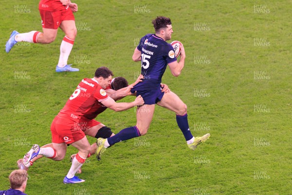 210226 - Wales v Scotland - Guinness Six Nations - Tomos Williams and Alex Mann of Wales tackle Blair Kinghorn of Scotland