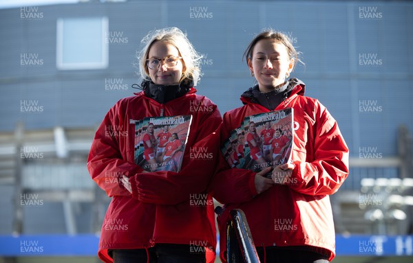 230324 - Wales v Scotland, Guinness Women’s 6 Nations - Copies of Women’s Health magazine featuring members of the Wales team are headed to fans as they enter the stadium