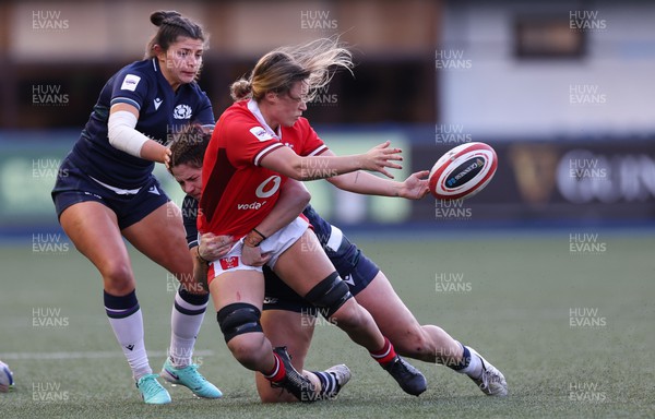 230324 - Wales v Scotland, Guinness Women’s 6 Nations - Alisha Butchers of Wales offloads as she  is tackled by Christine Belisle of Scotland