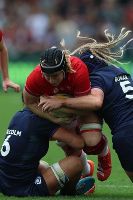 230825 - Wales v Scotland, Women’s Rugby World Cup - Bethan Lewis of Wales takes on Rachel Malcolm of Scotland and Sarah Bonar of Scotland