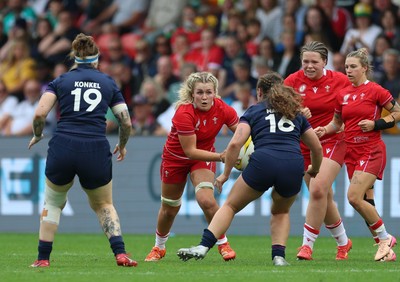 230825 - Wales v Scotland, Women’s Rugby World Cup - Alex Callender of Wales takes on Elis Martin of Scotland and Jade Konkel of Scotland