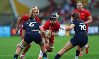 230825 - Wales v Scotland, Women’s Rugby World Cup - Bethan Lewis of Wales takes on Helen Nelson of Scotland and Rachel Malcolm of Scotland