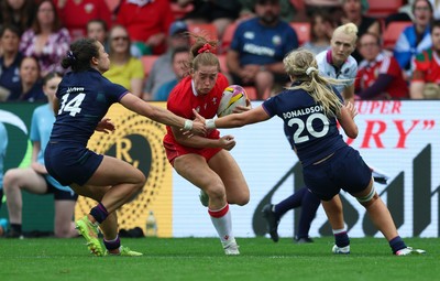 230825 - Wales v Scotland, Women’s Rugby World Cup - Lisa Neumann of Wales takes on Rhona Lloyd of Scotland and Eva Donaldson of Scotland