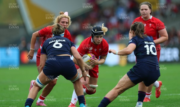230825 - Wales v Scotland, Women’s Rugby World Cup - Bethan Lewis of Wales takes on Helen Nelson of Scotland and Rachel Malcolm of Scotland