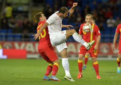 100913 -  Wales v Serbia - FIFA 2014 World Cup Qualifying Match -   Aaron Ramsey of Wales is beaten by the challenge from Branslav Ivanovic of Serbia( c ) Huw Evans Agency