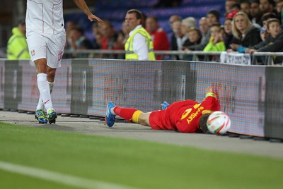 100913 - Wales v Serbia, FIFA 2014 World Cup Qualifying - Wales' Aaron Ramsey lies injured after colliding with the advertising displays- (c) Huw Evans Picture Agency, Cardiff