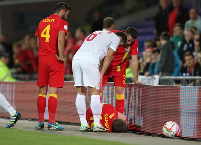 100913 - Wales v Serbia, FIFA 2014 World Cup Qualifying - Wales' Aaron Ramsey lies injured after colliding with the advertising displays- (c) Huw Evans Picture Agency, Cardiff